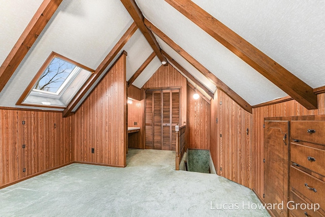 additional living space with vaulted ceiling with skylight, carpet flooring, wood walls, and a textured ceiling