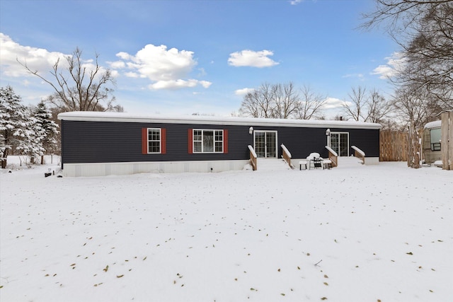 view of snow covered back of property