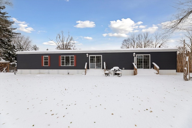 view of snow covered rear of property