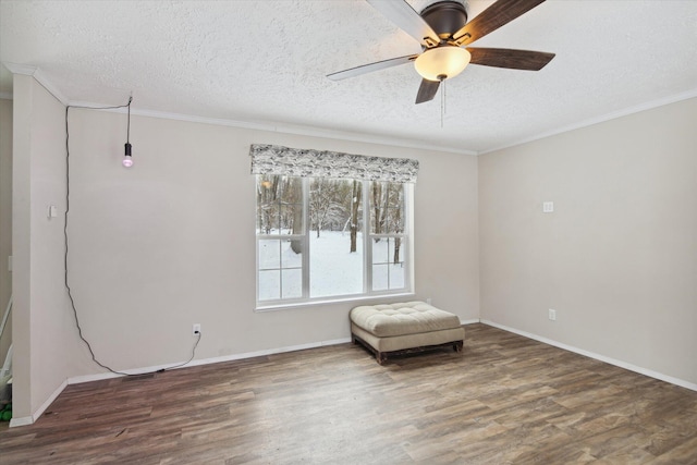 spare room featuring ceiling fan, dark wood-type flooring, a textured ceiling, and crown molding