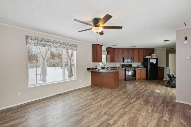 kitchen featuring a textured ceiling, dark hardwood / wood-style floors, black appliances, and kitchen peninsula