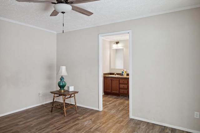 interior space featuring ceiling fan, dark hardwood / wood-style floors, sink, and a textured ceiling