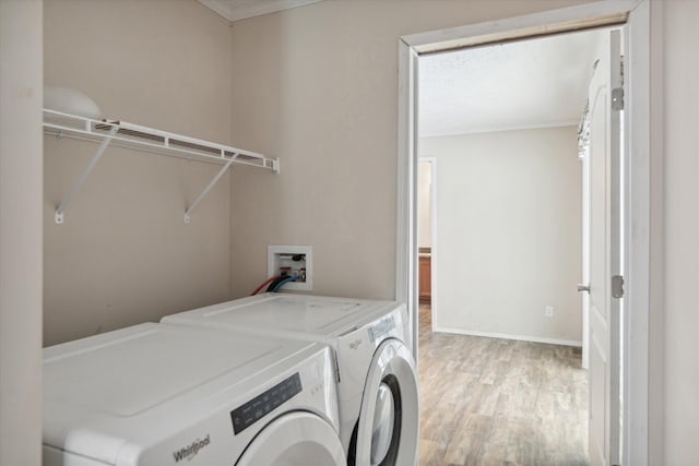 laundry area featuring separate washer and dryer, ornamental molding, and hardwood / wood-style floors