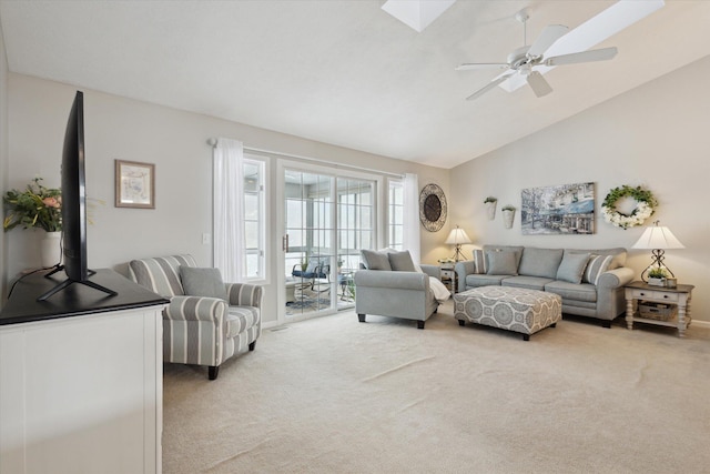 living room with light carpet, ceiling fan, and lofted ceiling with skylight