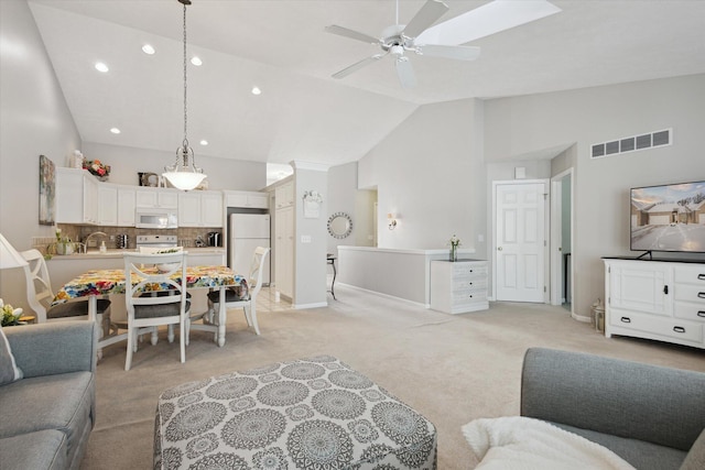 living room featuring sink, ceiling fan, high vaulted ceiling, and light carpet