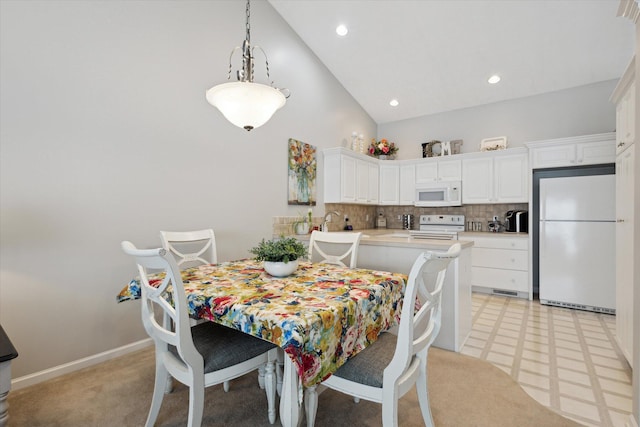 dining room featuring high vaulted ceiling and sink