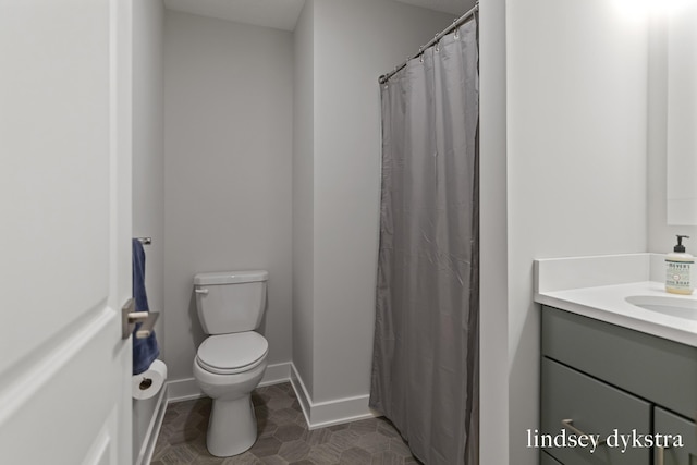 bathroom featuring toilet, vanity, and tile patterned flooring