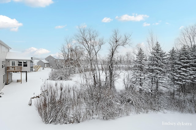 yard layered in snow featuring a deck