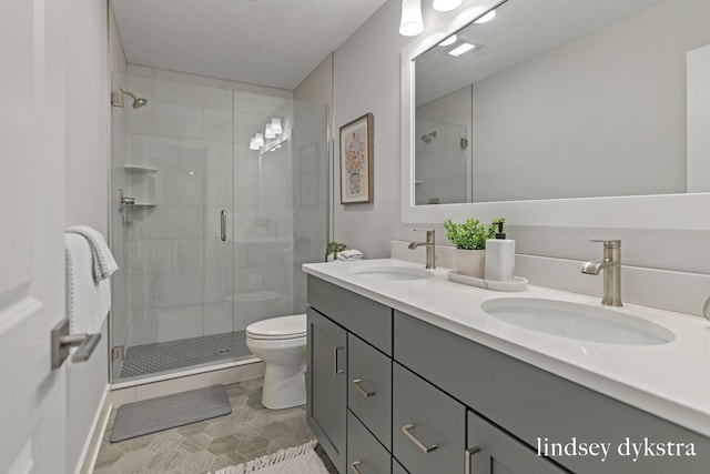 bathroom featuring toilet, vanity, tile patterned flooring, and an enclosed shower