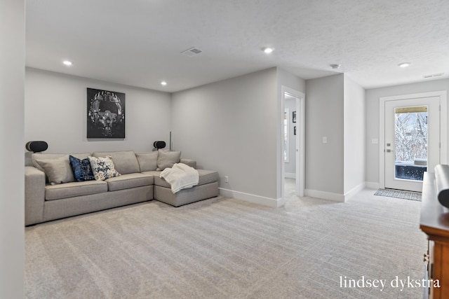 carpeted living room featuring a textured ceiling