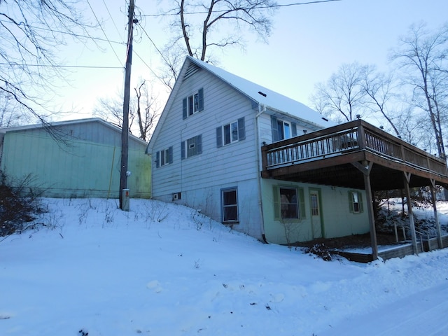 snow covered rear of property featuring a wooden deck