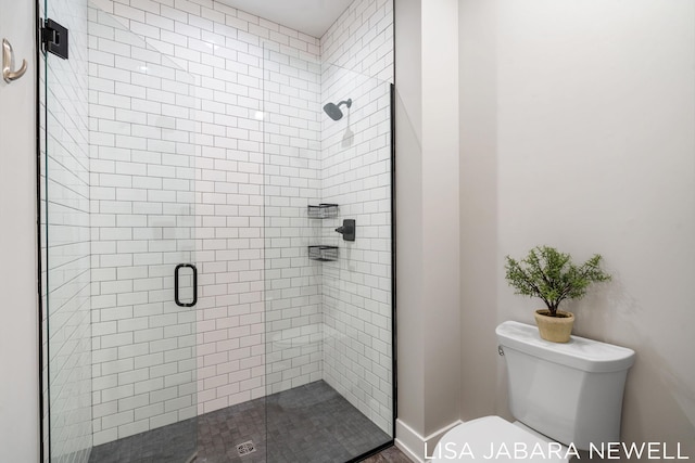 bathroom with a shower with shower door and toilet