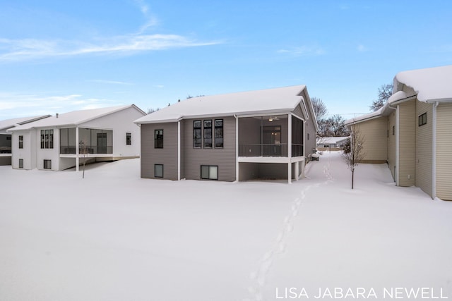 snow covered house with a sunroom