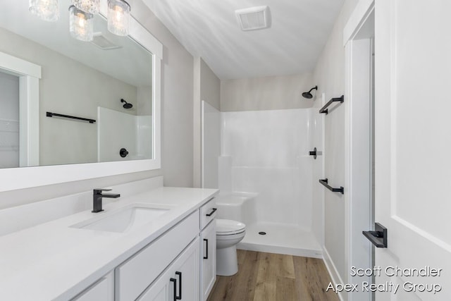 bathroom with walk in shower, vanity, wood-type flooring, and toilet