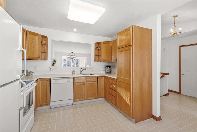 kitchen featuring sink, decorative light fixtures, white appliances, and a notable chandelier