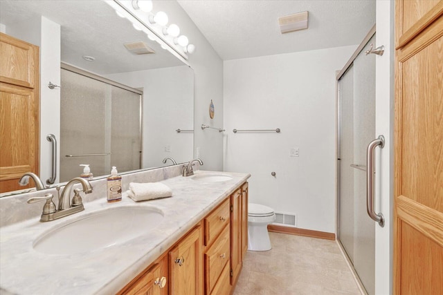 bathroom with vanity, toilet, walk in shower, and a textured ceiling