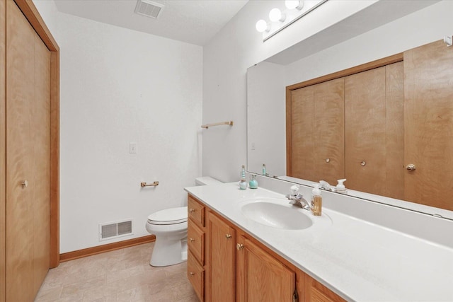 bathroom featuring a textured ceiling, toilet, and vanity