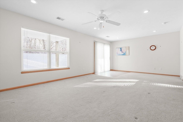 empty room with ceiling fan and light carpet