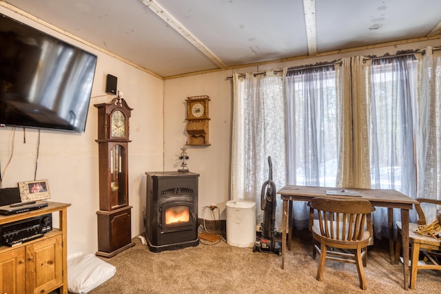 living area with a wood stove, plenty of natural light, and light carpet