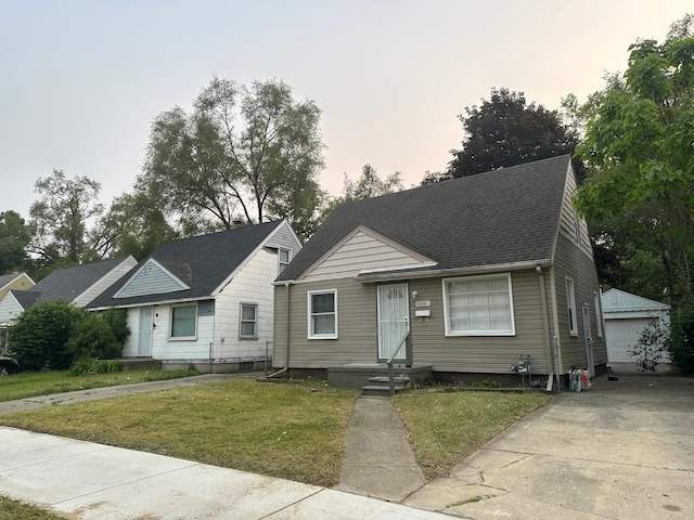 view of front facade featuring a garage, a yard, and an outdoor structure