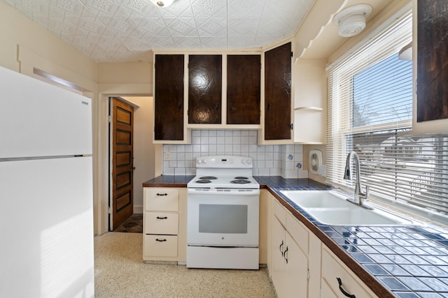 kitchen featuring dark brown cabinetry, sink, white cabinetry, white appliances, and backsplash