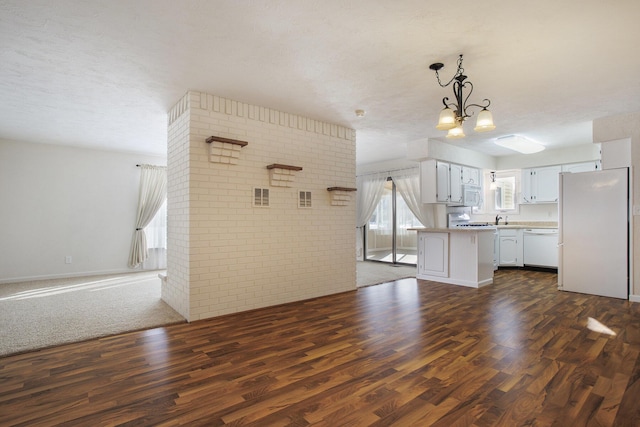 kitchen with white cabinets, brick wall, white appliances, and dark hardwood / wood-style flooring