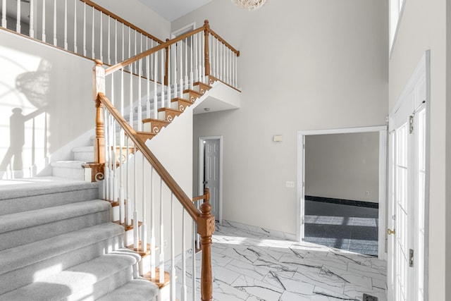 staircase featuring a towering ceiling