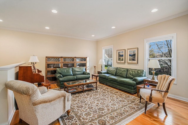 living room featuring light hardwood / wood-style flooring, crown molding, and plenty of natural light