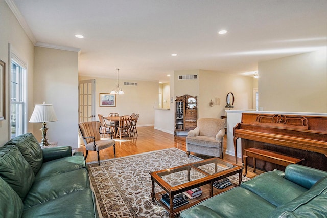 living room featuring ornamental molding and light hardwood / wood-style flooring