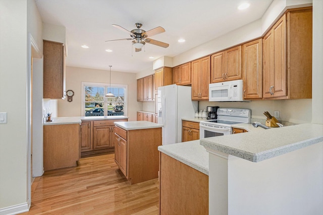 kitchen featuring pendant lighting, white appliances, light hardwood / wood-style floors, and kitchen peninsula