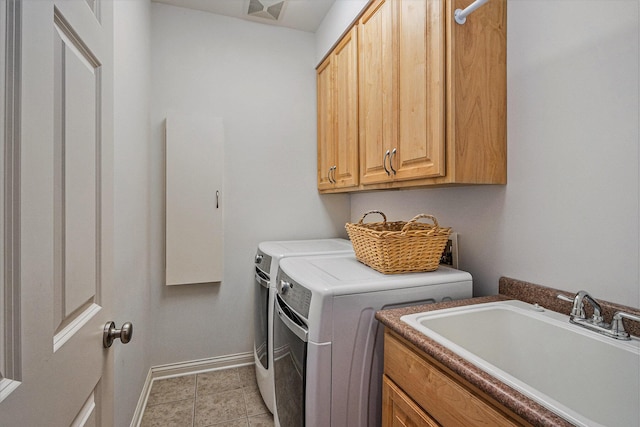 clothes washing area with cabinets, washer and dryer, sink, and light tile patterned floors