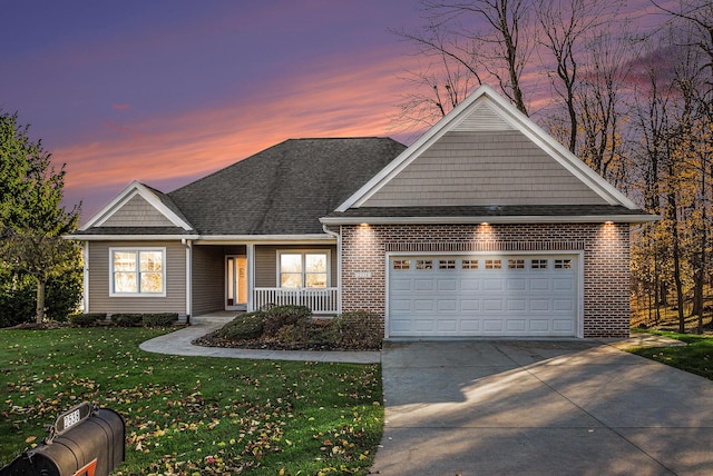 view of front of property with a porch, a garage, and a lawn