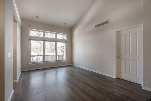 unfurnished room with high vaulted ceiling and dark wood-type flooring