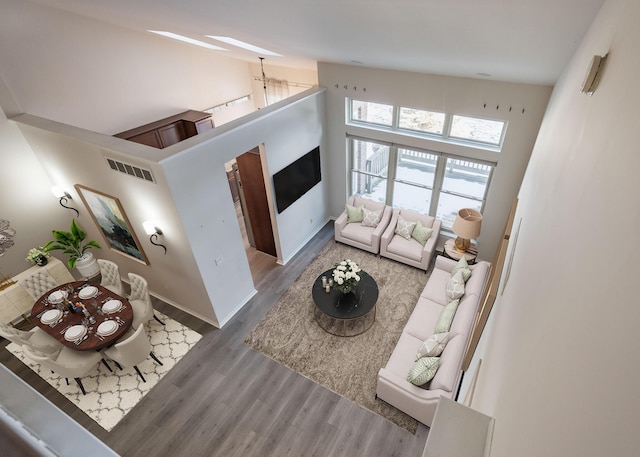 living room with hardwood / wood-style flooring and a high ceiling