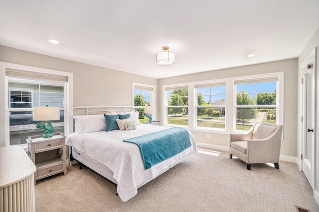 bedroom featuring light carpet and multiple windows