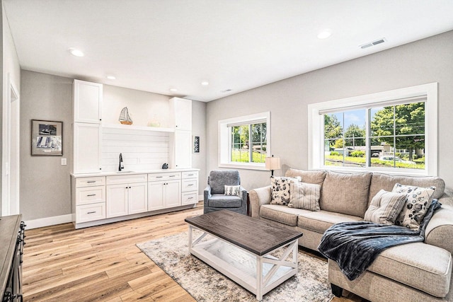 living room with sink and light hardwood / wood-style flooring