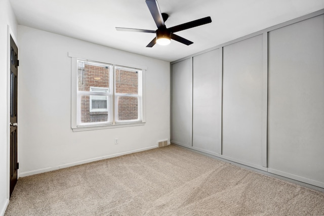 unfurnished bedroom with light colored carpet, a closet, and ceiling fan