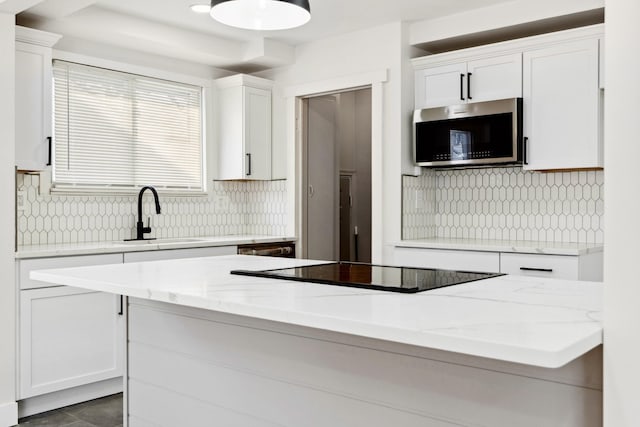 kitchen with white cabinets, stainless steel appliances, light stone counters, and sink