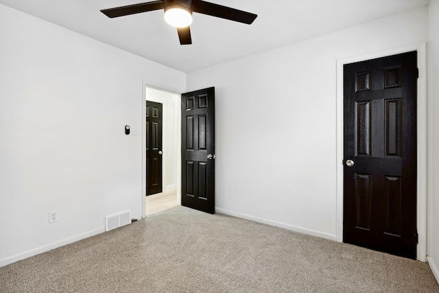 spare room with ceiling fan and light colored carpet