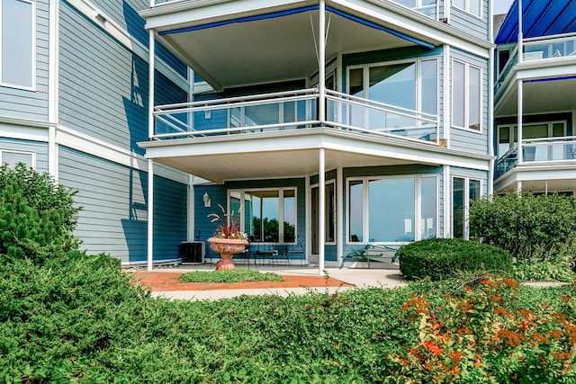 rear view of house featuring a balcony and cooling unit