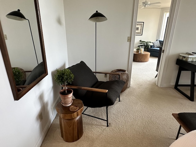 sitting room with ceiling fan and carpet flooring