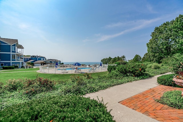 view of home's community featuring a swimming pool and a yard