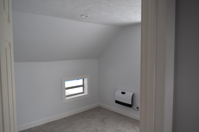 bonus room with light carpet, vaulted ceiling, and a textured ceiling