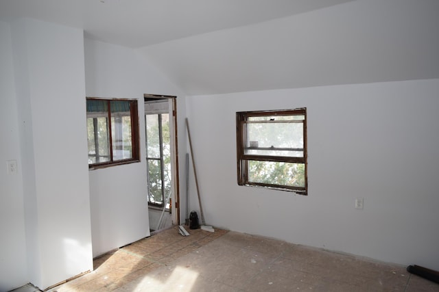 unfurnished room featuring lofted ceiling