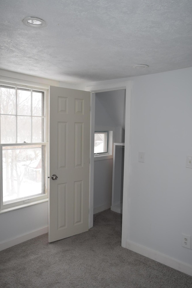 carpeted spare room with a textured ceiling