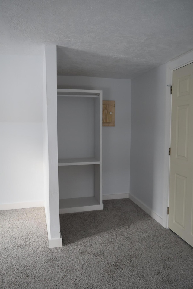 unfurnished bedroom featuring a closet, a textured ceiling, and carpet