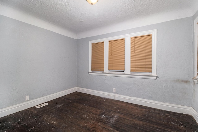 empty room featuring hardwood / wood-style floors and a textured ceiling