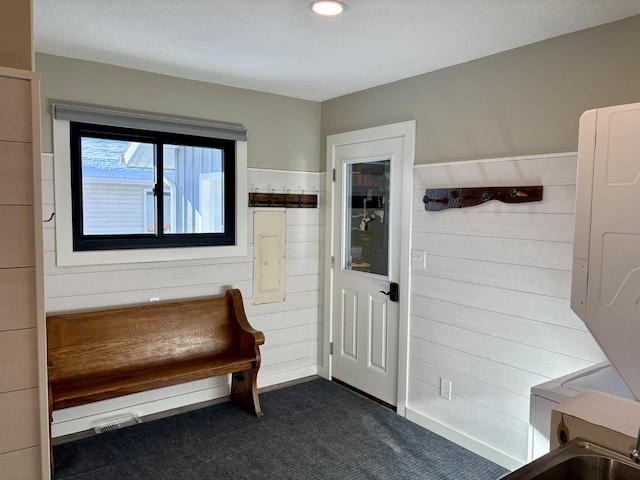 interior space with dark colored carpet and wood walls