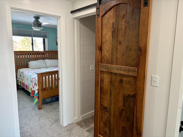 carpeted bedroom featuring a barn door