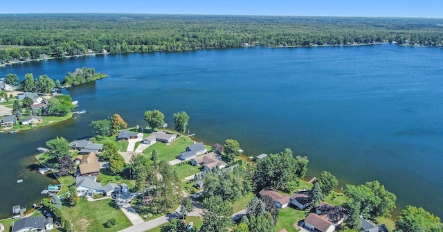 birds eye view of property featuring a water view, a residential view, and a wooded view